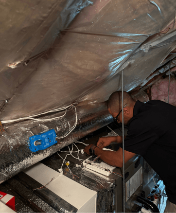 Jay Moody HVAC technician installing new ductwork and central heat pump in Worcester, MA home.