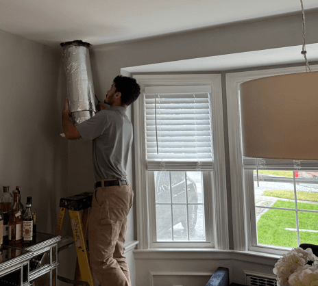 Jay Moody HVAC technician installing ductwork in kitchen/dining room area of WOrcester, MA home.