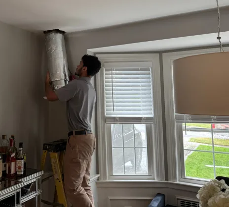Jay Moody HVAC technician installing ductwork in kitchen/dining room area of WOrcester, MA home.