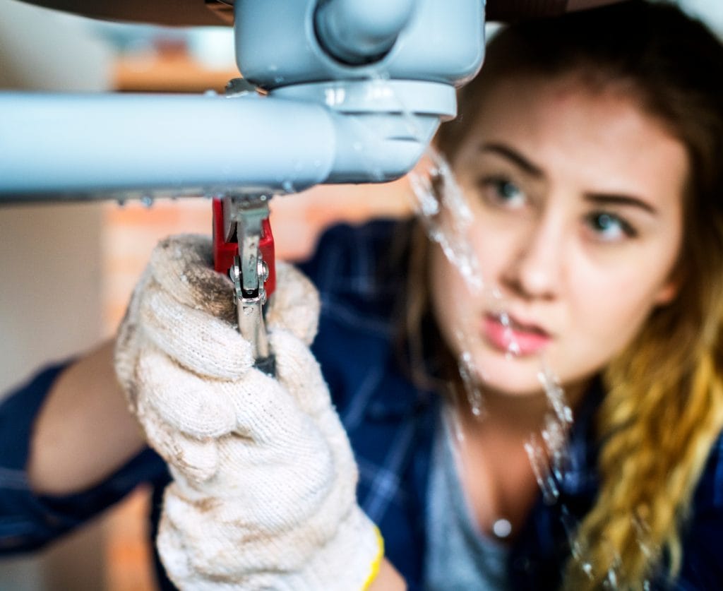 Women fixing burst pipe