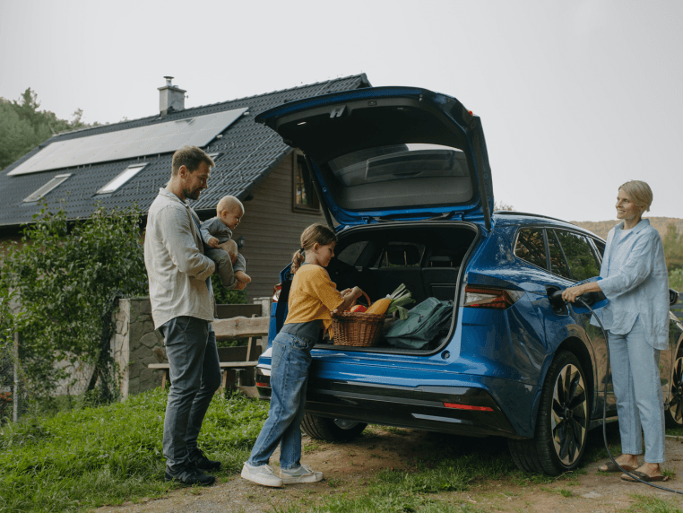 Family in front of home with solar mounted on roof.